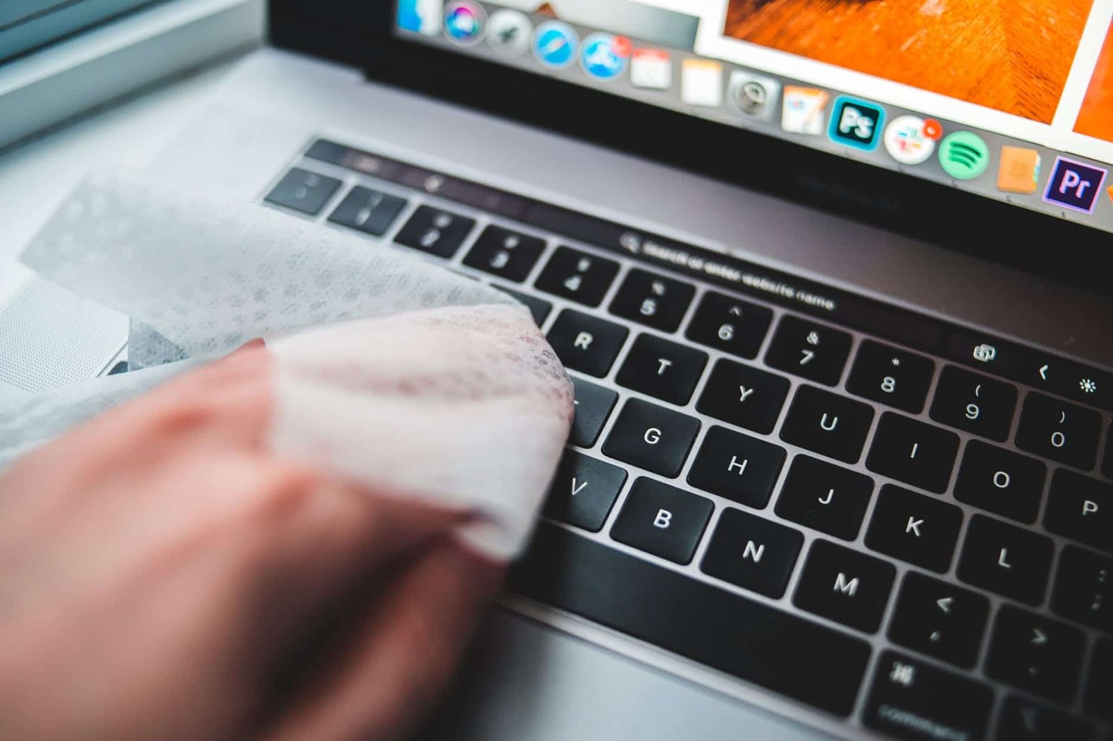 person cleaning keyboard